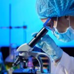 Woman examining sample with microscope