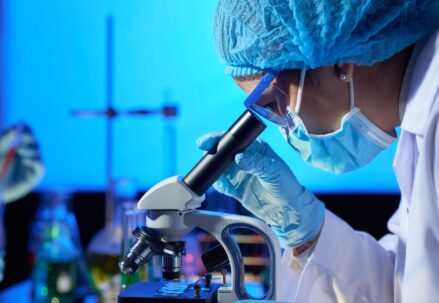 Woman examining sample with microscope