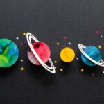 Planets depicted as colorful circular cutouts with stars on a black backdrop