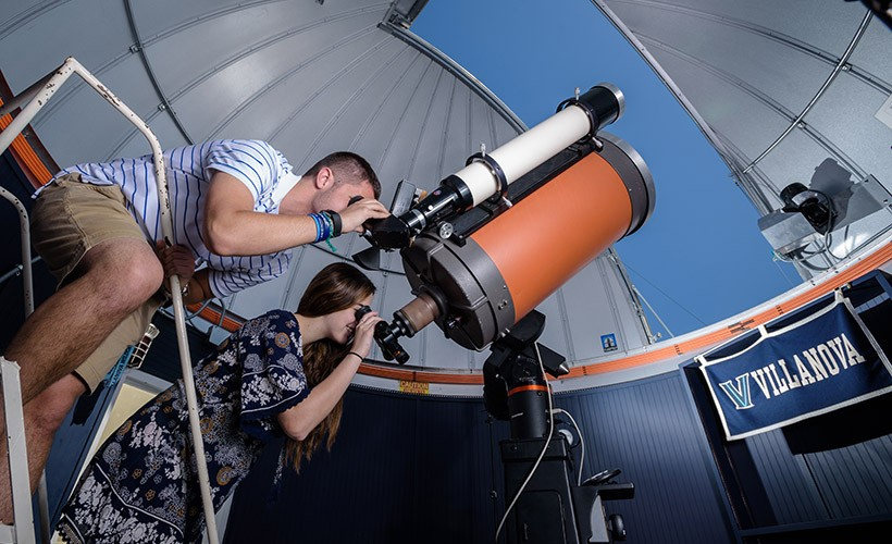 A man and a girl looking through a telescope